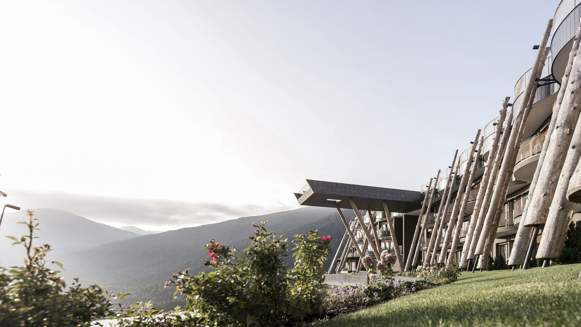 Hotel im Pustertal mit 5 Sternen Modernes Gebäude mit Holzelementen in bergiger Landschaft bei Sonnenaufgang