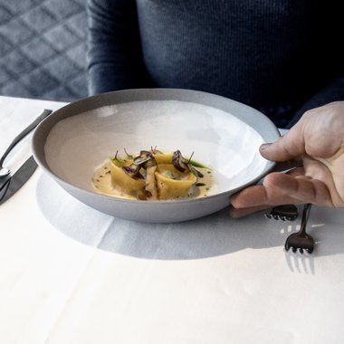 Il nostro programma estivo settimanale Donna riceve piatto con pasta raffinata e funghi al ristorante