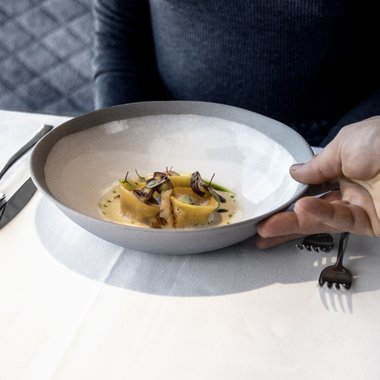 In vacanza in una splendida posizione Donna riceve piatto con pasta raffinata e funghi al ristorante