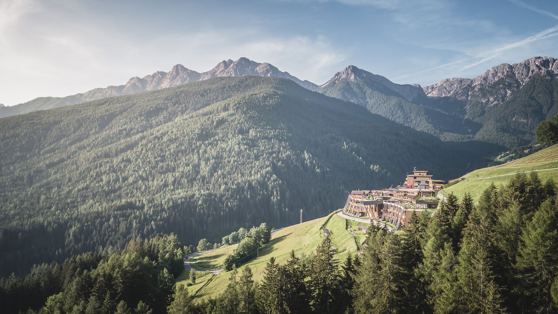 Aktuelle News und Geschichten aus Olang Berge mit Wald und Gebäuden auf sonnigem Berghang