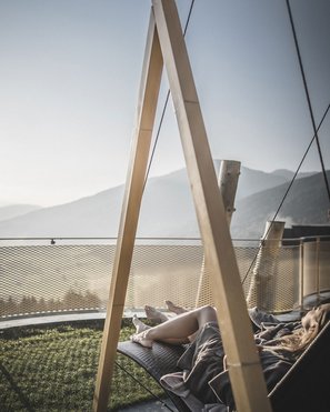 Unsere Parks, Ihre Rückzugsorte Person liegt entspannt auf einer Hängematte mit Bergblick